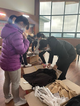 Image of Mayflower church members receiving clothes donated by local churches while they are in exile.