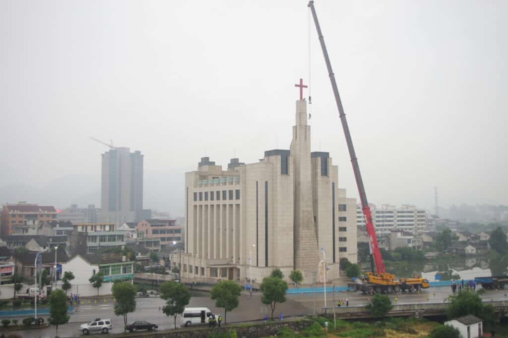Construction workers remove a cross from a massive church in China